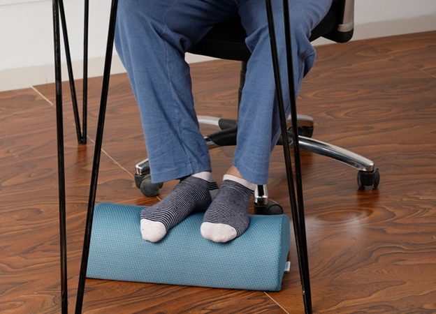 What are the benefits of using a footrest under a desk?